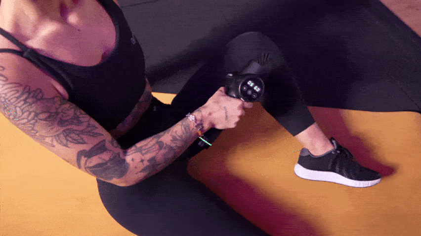 Korištenje masažnog pištolja na prednjoj strani bedara Korištenje masažnog pištolja na prednjoj strani bedara